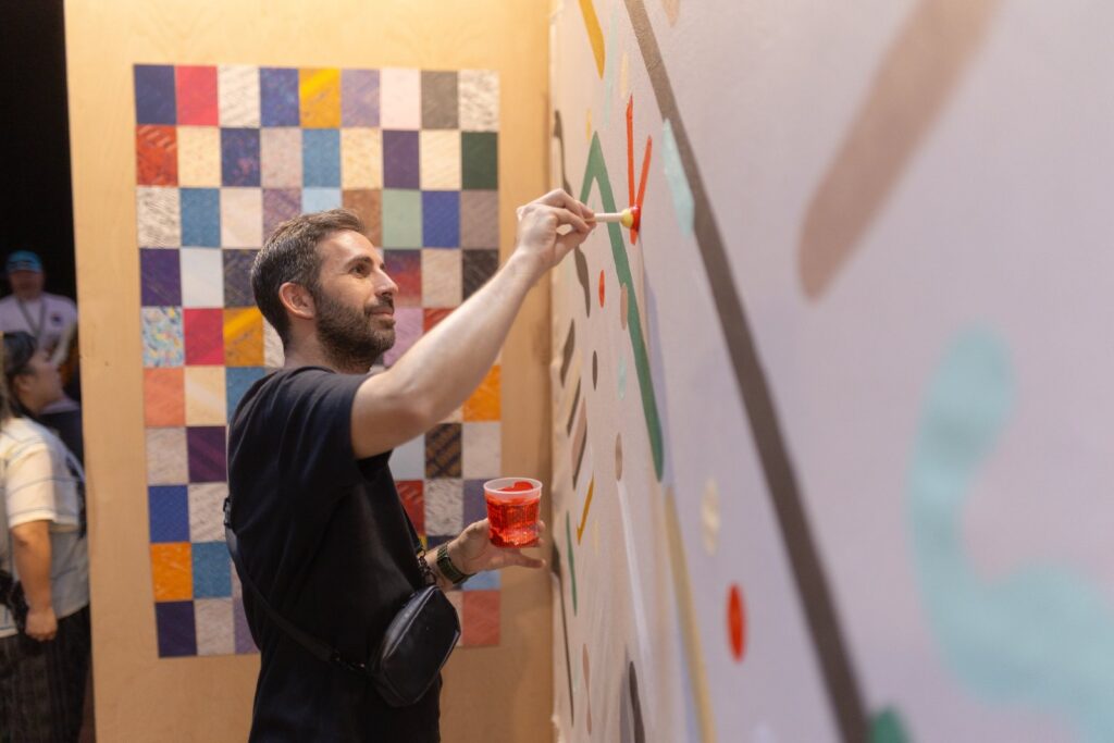 Artist painting a mural during Art Blocks Marfa Weekend, the generative art gathering in Marfa, Texas